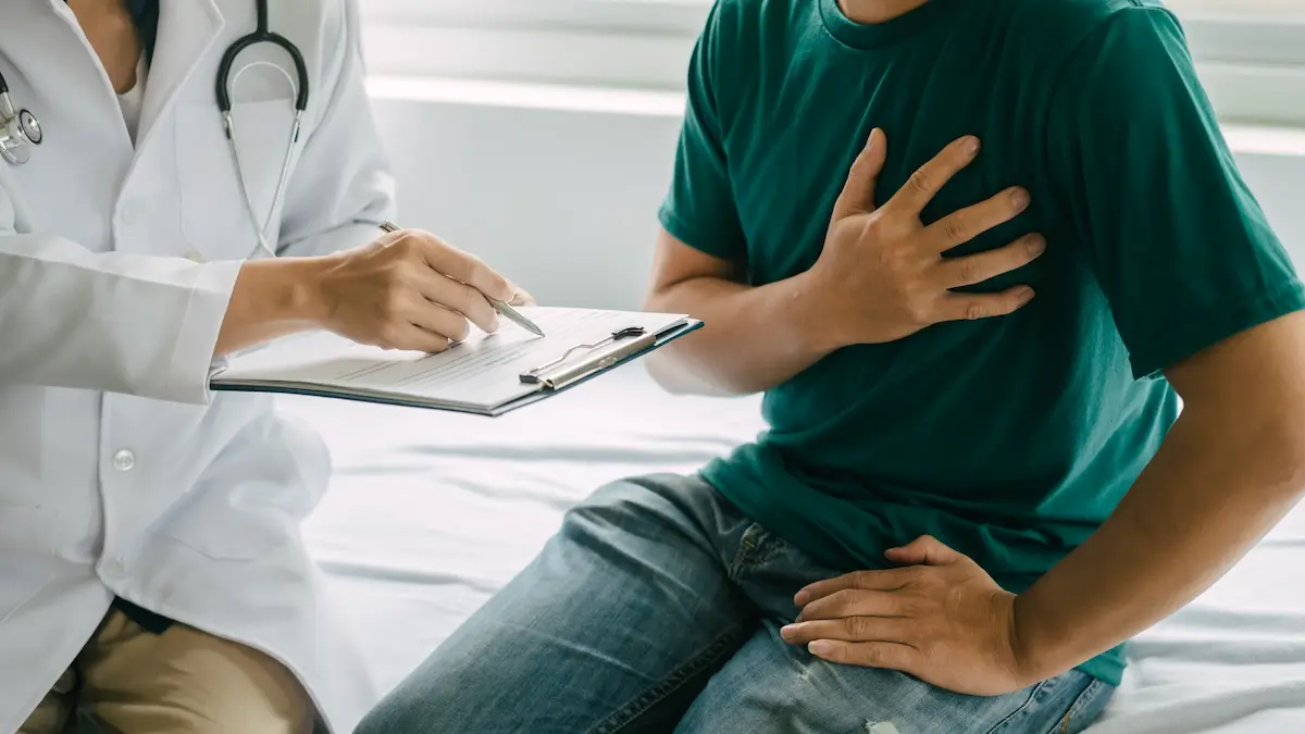 man experiencing chest pain at doctors