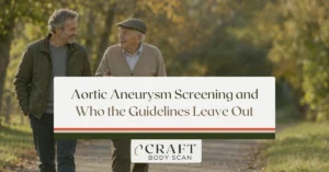 Son in his late 50s walking with his elderly father on an autumn path, a reminder that family history matters in aortic aneurysm screening